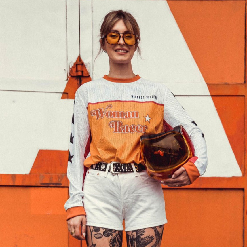 Model wearing motorcycle helmet and Wildust Sisters Jersey Cross – Woman Racer, front view