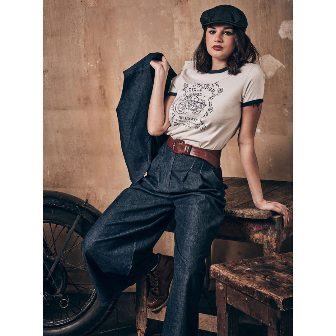 Wildust Sisters Riders Club t-shirt women’s lifestyle image styled with denim trousers and jacket in vintage workshop setting