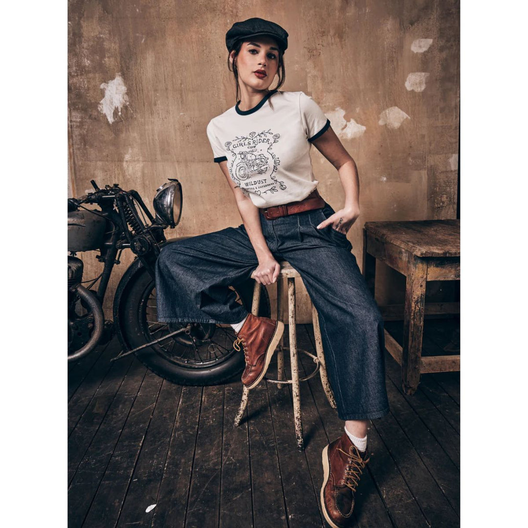 Wildust Sisters Riders Club t-shirt women’s lifestyle image seated pose with vintage motorcycle and workwear styling