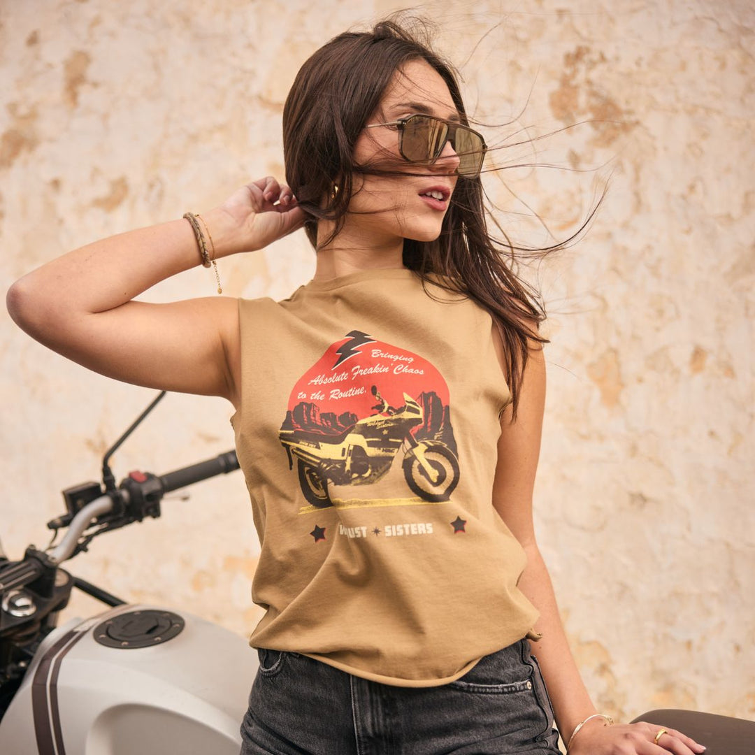 Wildust Sisters Take a Trip tank top women’s lifestyle image with windblown hair and motorcycle backdrop