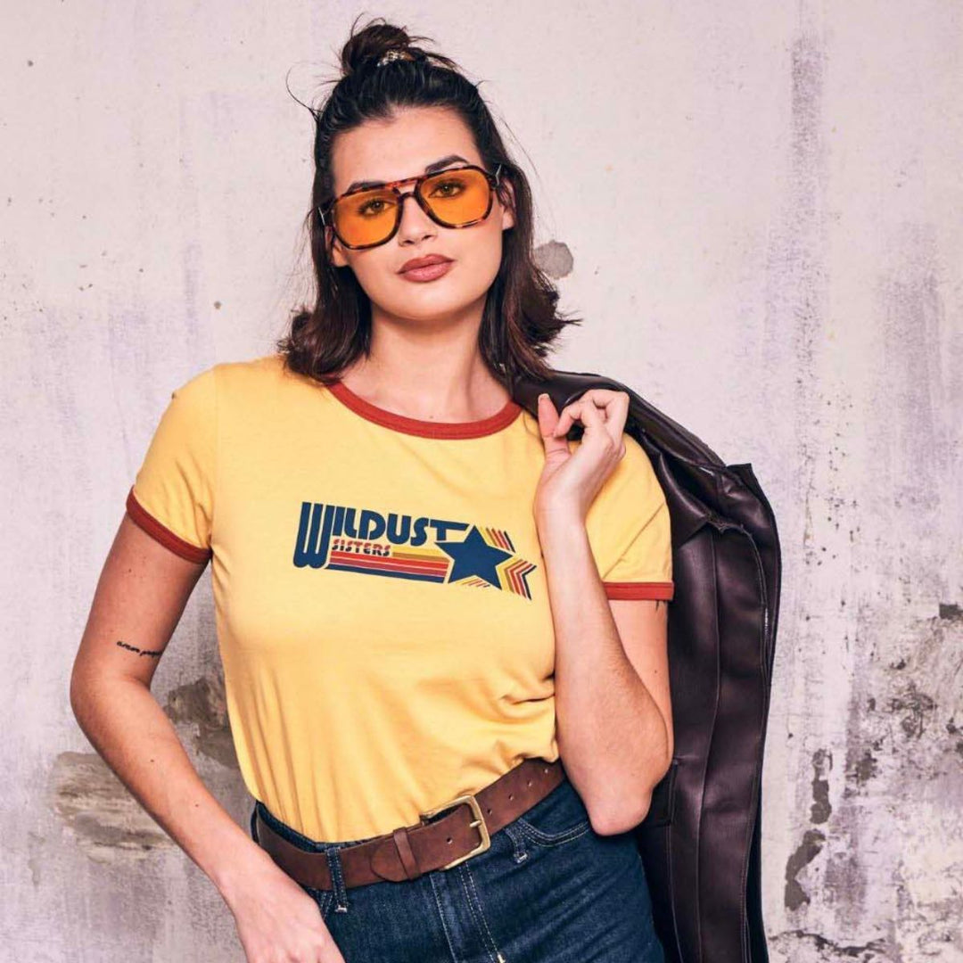 Wildust Sisters Wildust Racing ringer t-shirt yellow women’s lifestyle image with retro logo and sunglasses